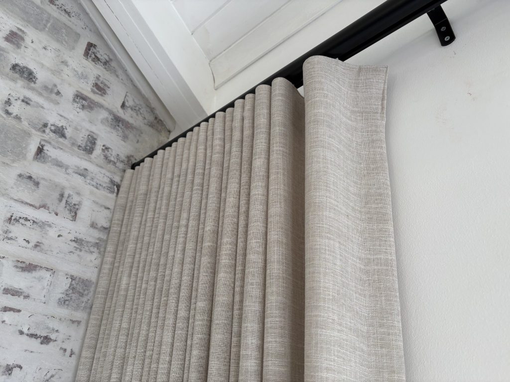 Floor-length bespoke curtains framing a bright living-room window